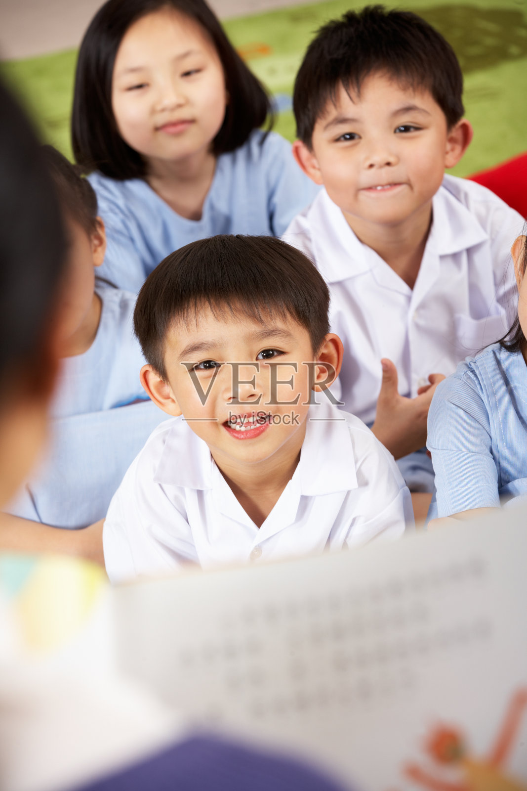 在中文学校的教室里，老师给学生朗读照片摄影图片