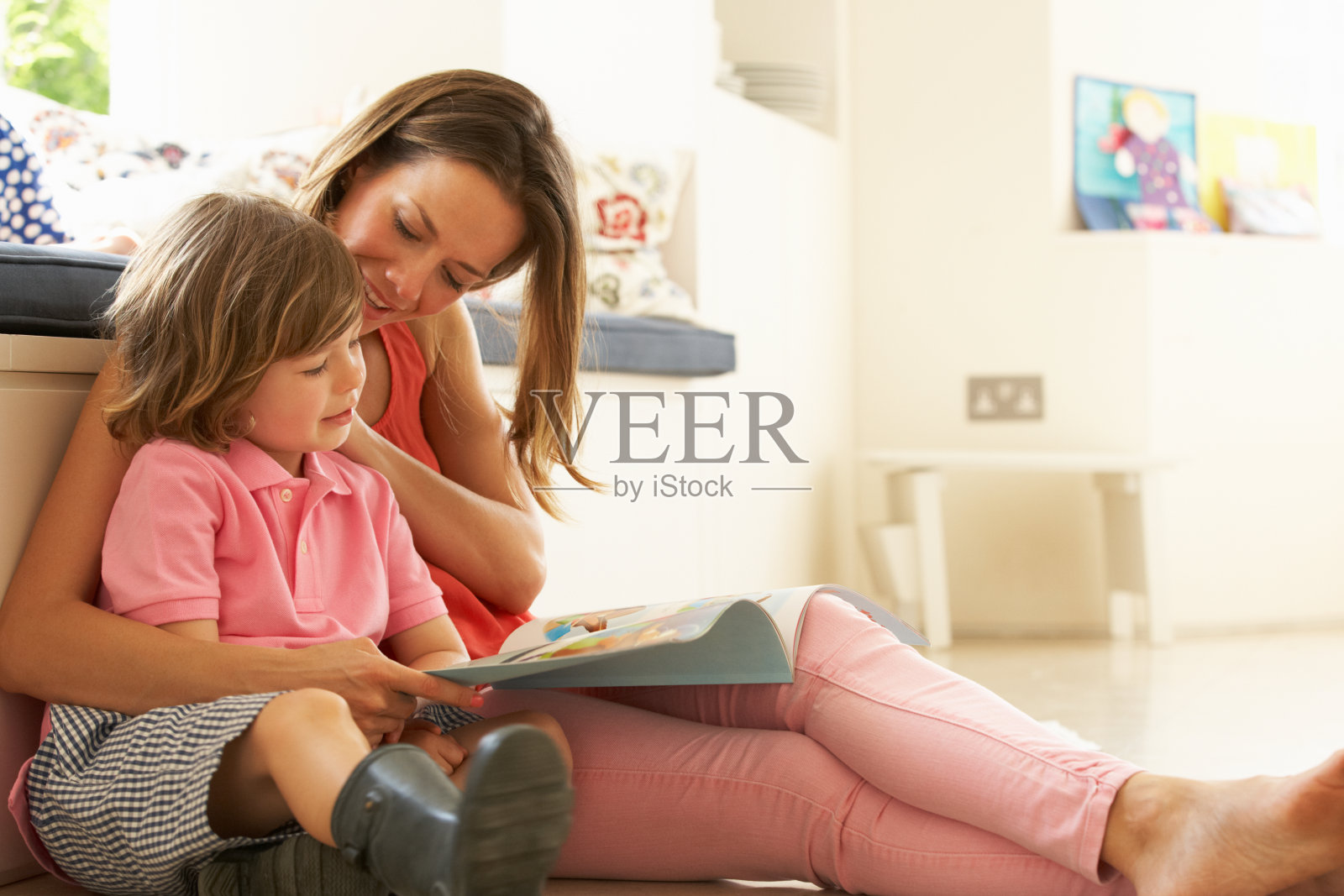 母亲和儿子坐在室内读故事照片摄影图片
