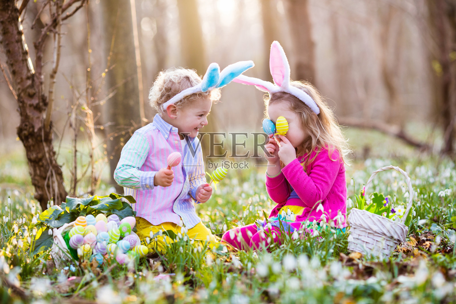 孩子们在春天的花园里寻找复活节彩蛋照片摄影图片