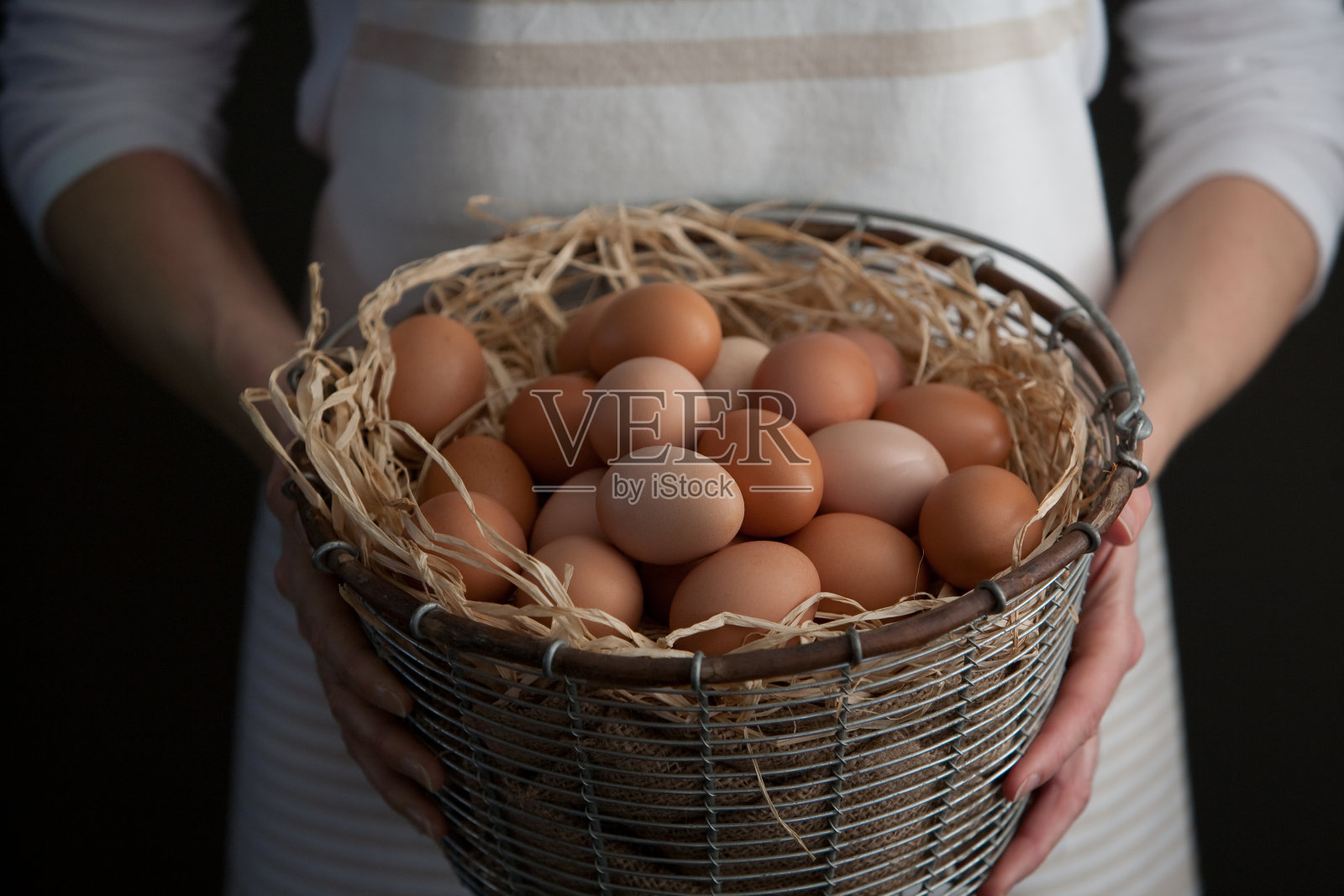 拿着一篮子新鲜农场鸡蛋的女人照片摄影图片