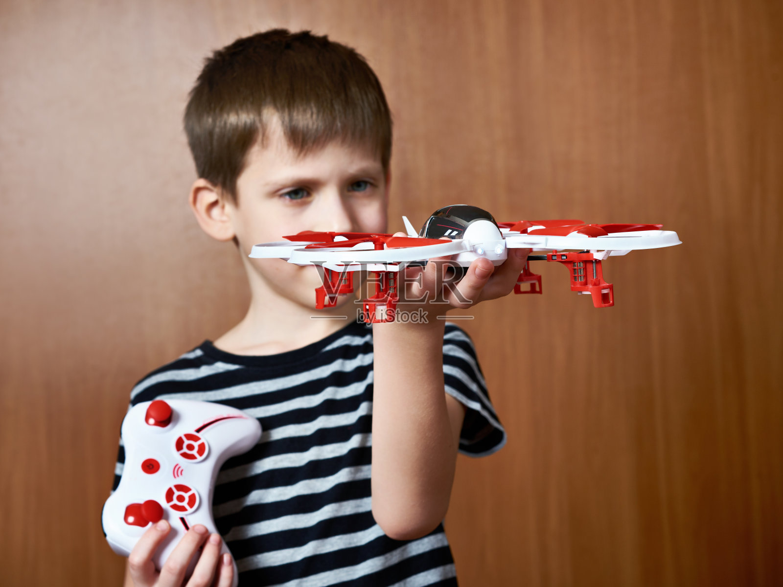 带着玩具四旋翼无人机的小男孩照片摄影图片