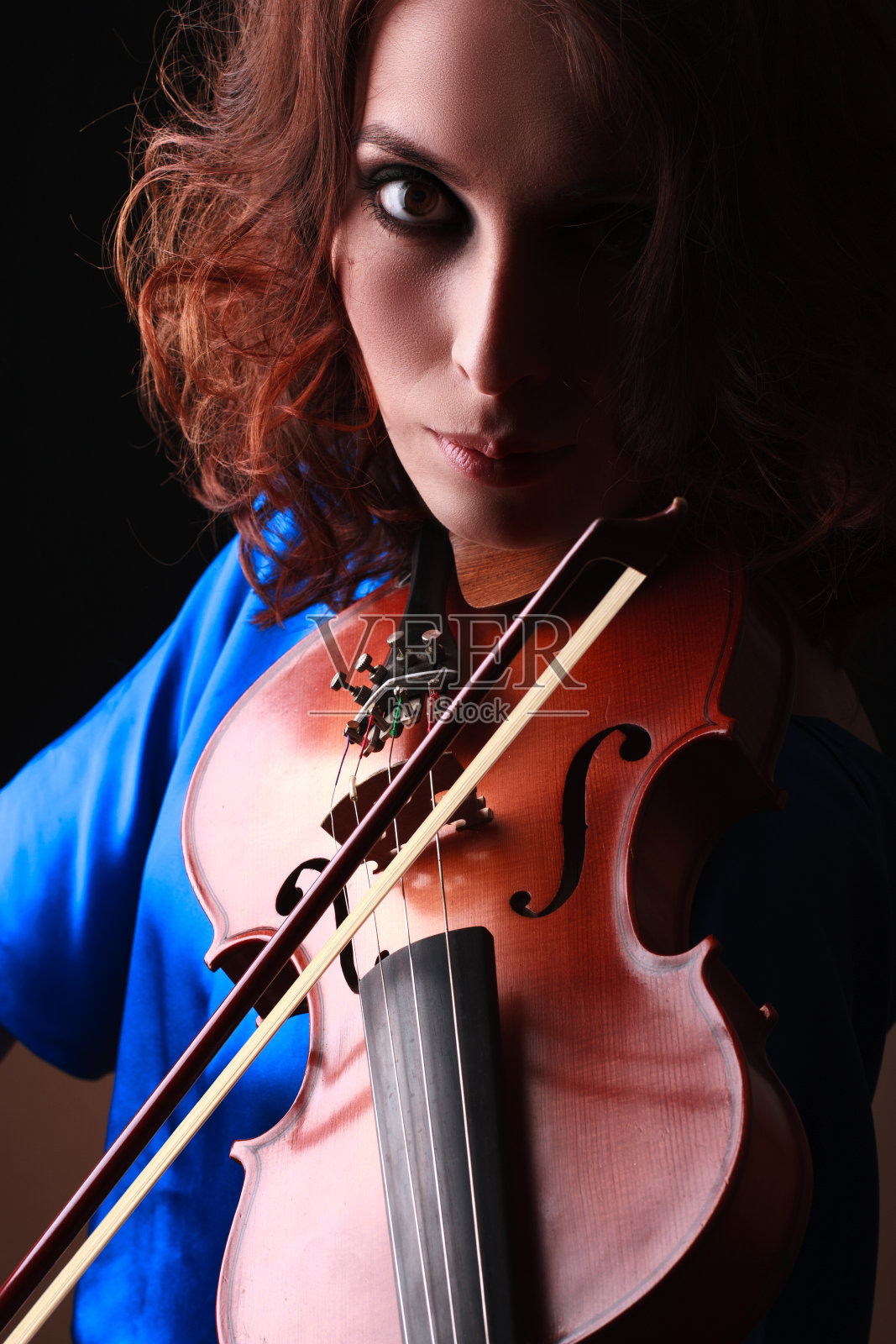 一位正在拉小提琴的年轻女性的肖像照片摄影图片