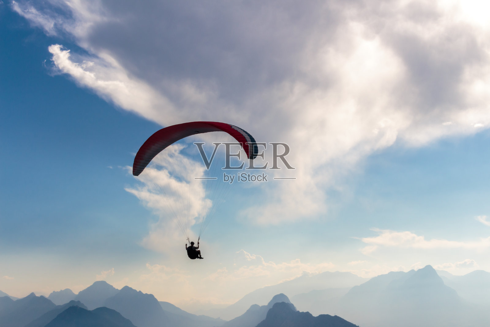 降落伞和人形剪影。天空蓝的冒险。照片摄影图片