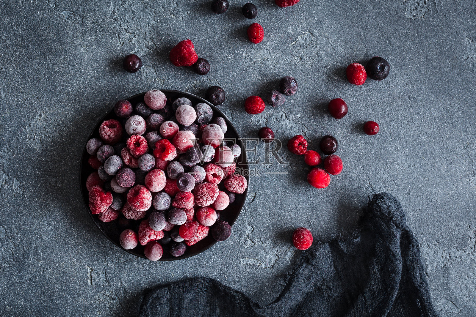 冰冻覆盆子，蓝莓，蔓越莓在黑暗的背景照片摄影图片