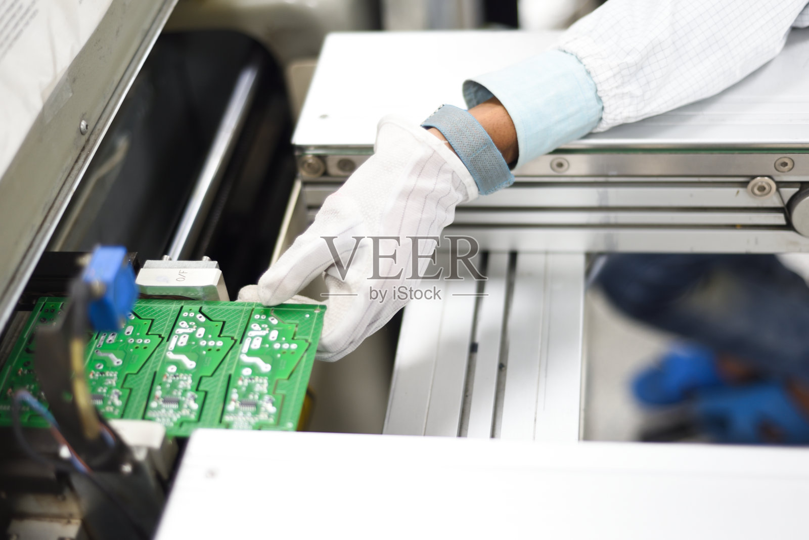 电子工厂工人从SMT生产线上拆卸印刷电路板的手照片摄影图片