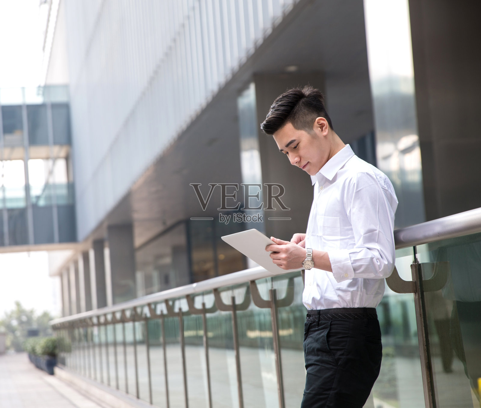 年轻的亚洲商人在办公室外使用平板电脑照片摄影图片