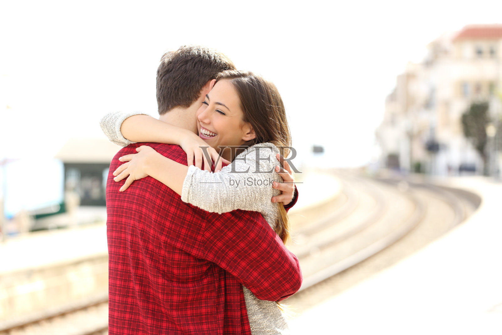 一对情侣在火车站愉快地拥抱照片摄影图片