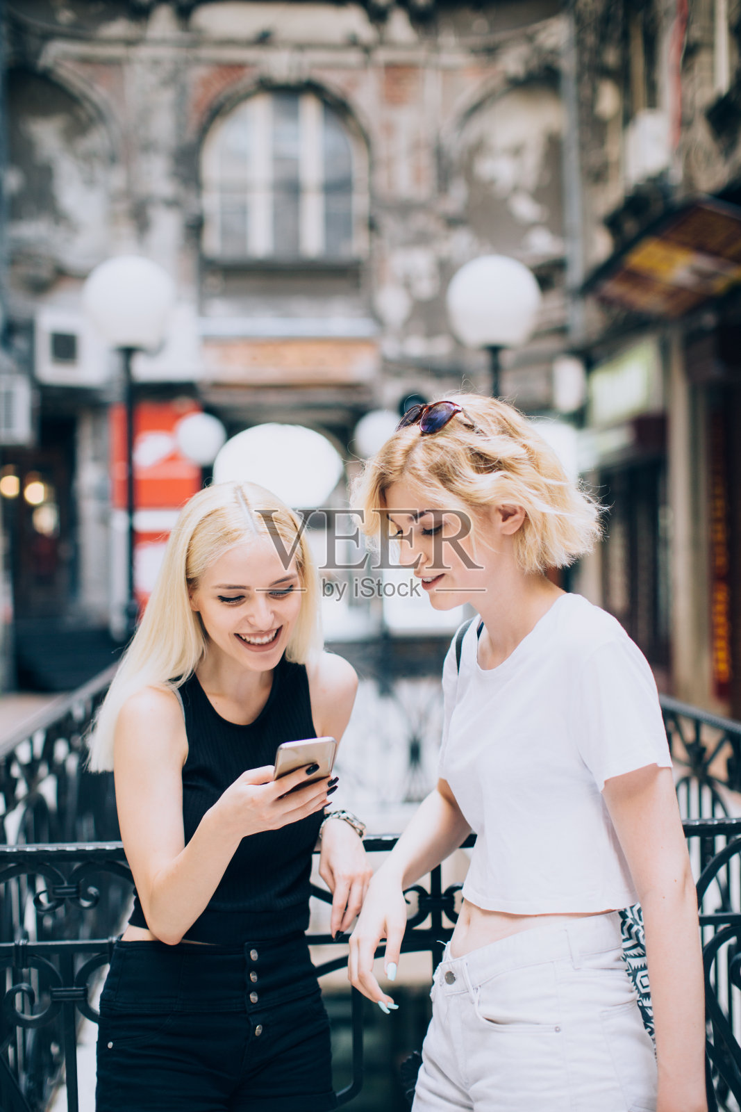 两个女性朋友在街上用手机照片摄影图片