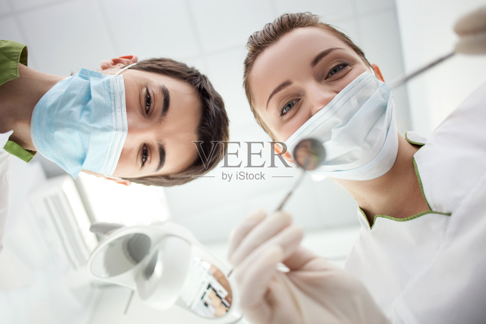 熟练的年轻女牙医正在治疗人类的牙齿照片摄影图片