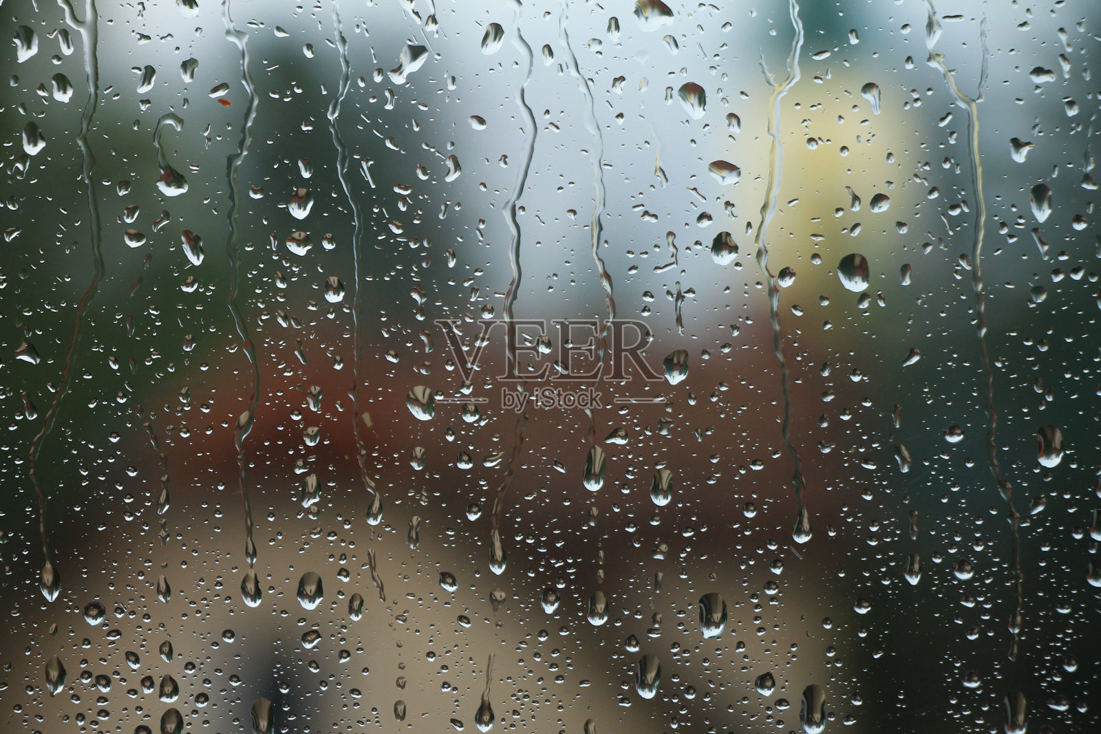 雨点落在窗户上，房子和教堂是背景照片摄影图片
