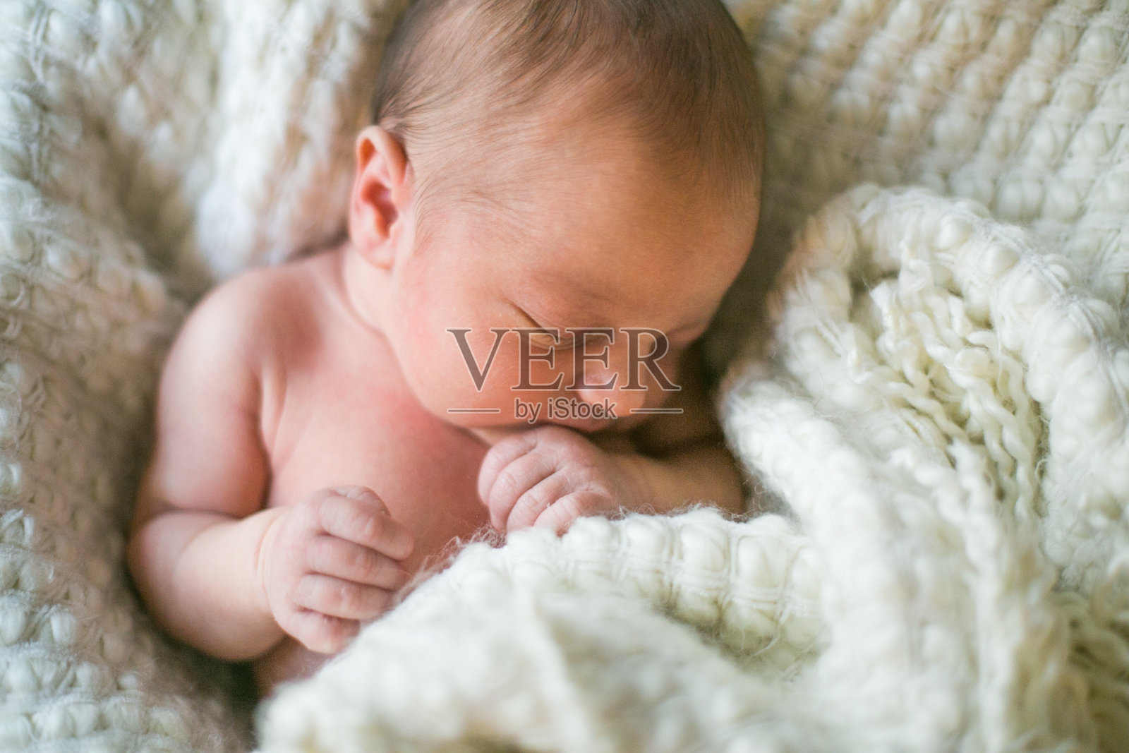 新生儿睡在毯子里照片摄影图片