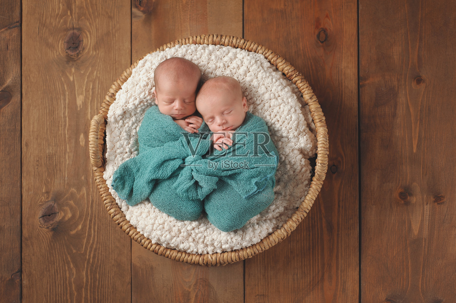 双胞胎男婴睡在篮子里照片摄影图片