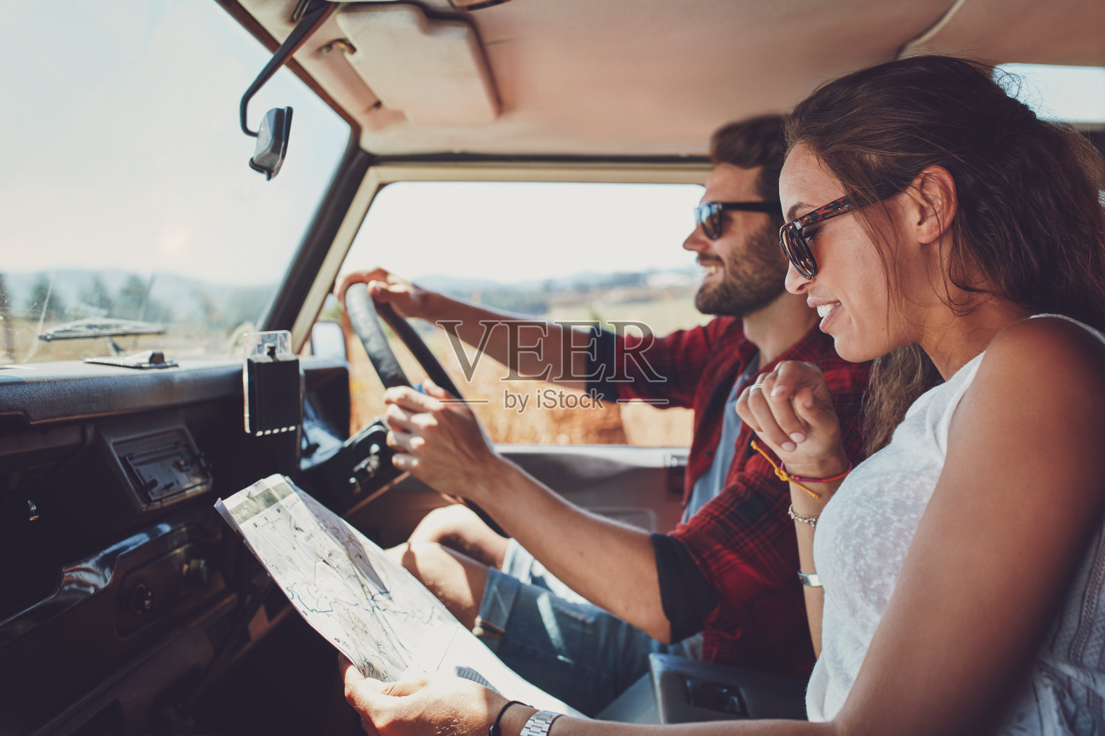 一对年轻夫妇在公路旅行中使用地图问路照片摄影图片
