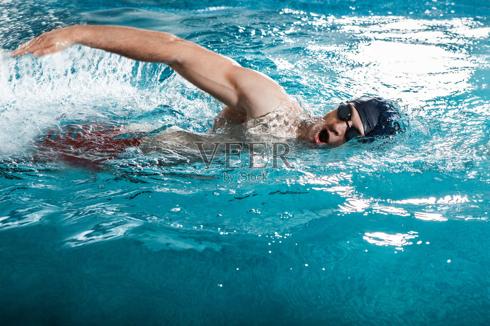 一个年轻人在游泳池里游着泳照片摄影图片