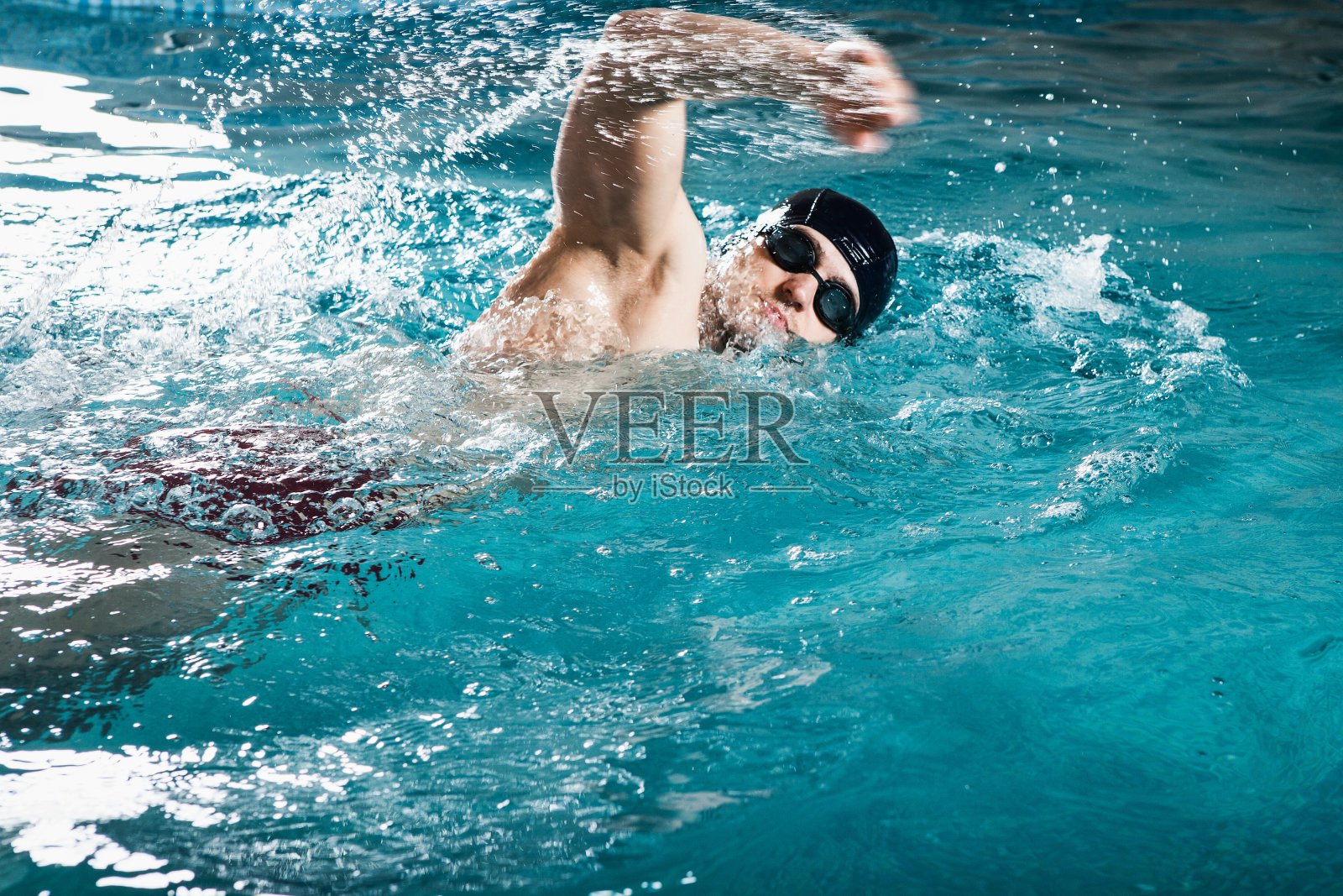 一个年轻人在游泳池里游着泳照片摄影图片