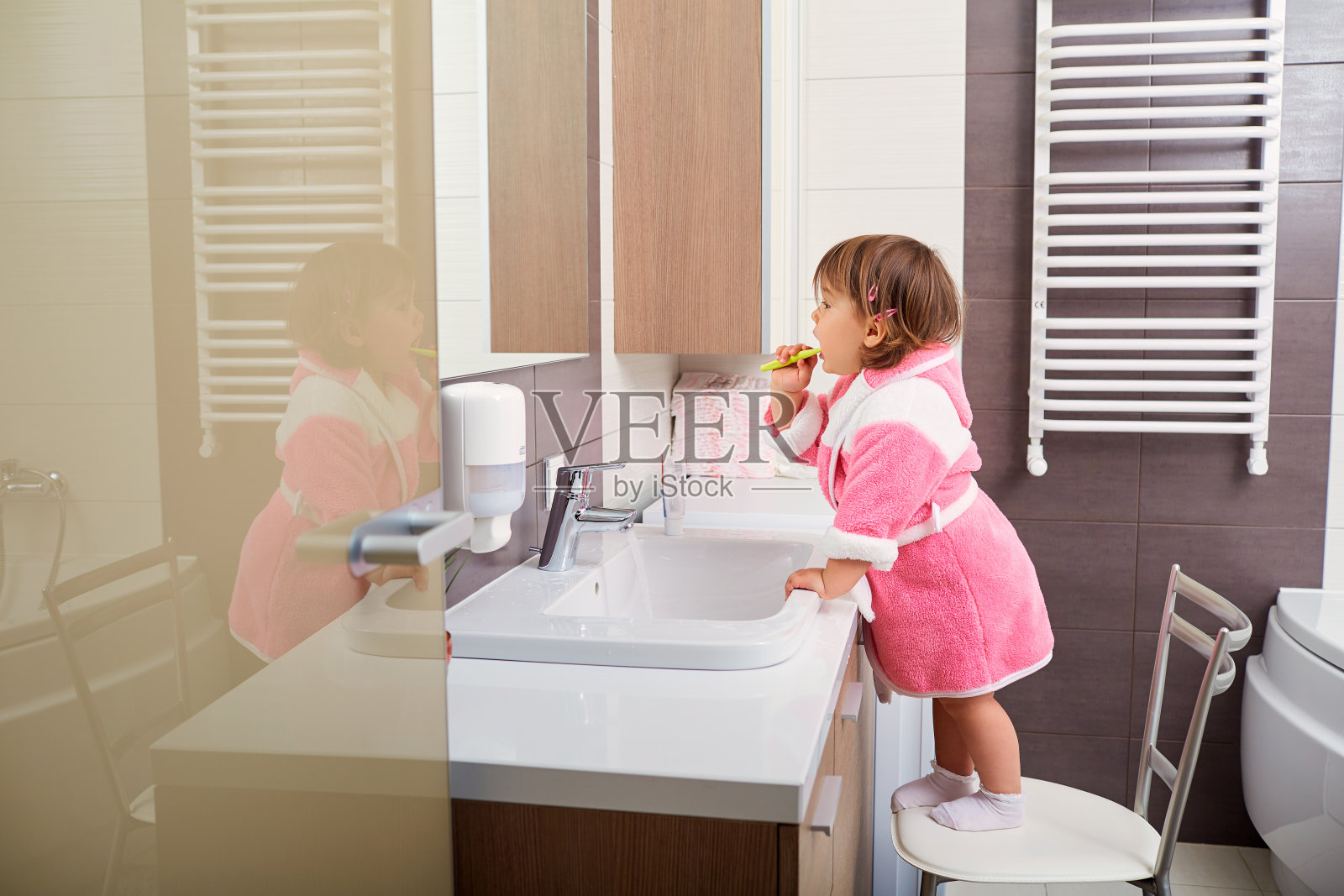 孩子在浴室里刷牙。照片摄影图片