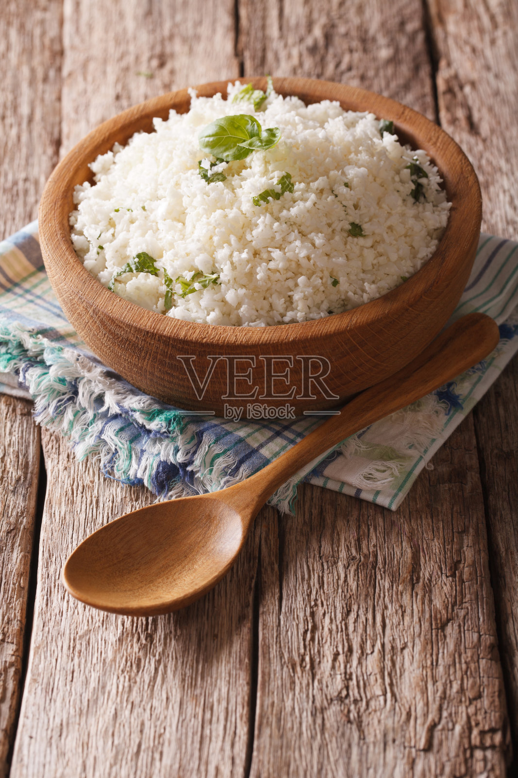 原始人食物:花椰菜米饭配香草。垂直照片摄影图片