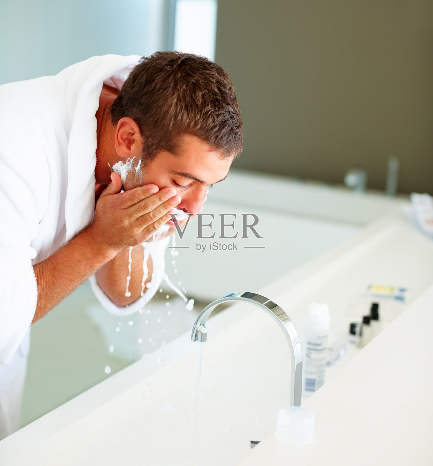 男子剃须后洗脸照片摄影图片