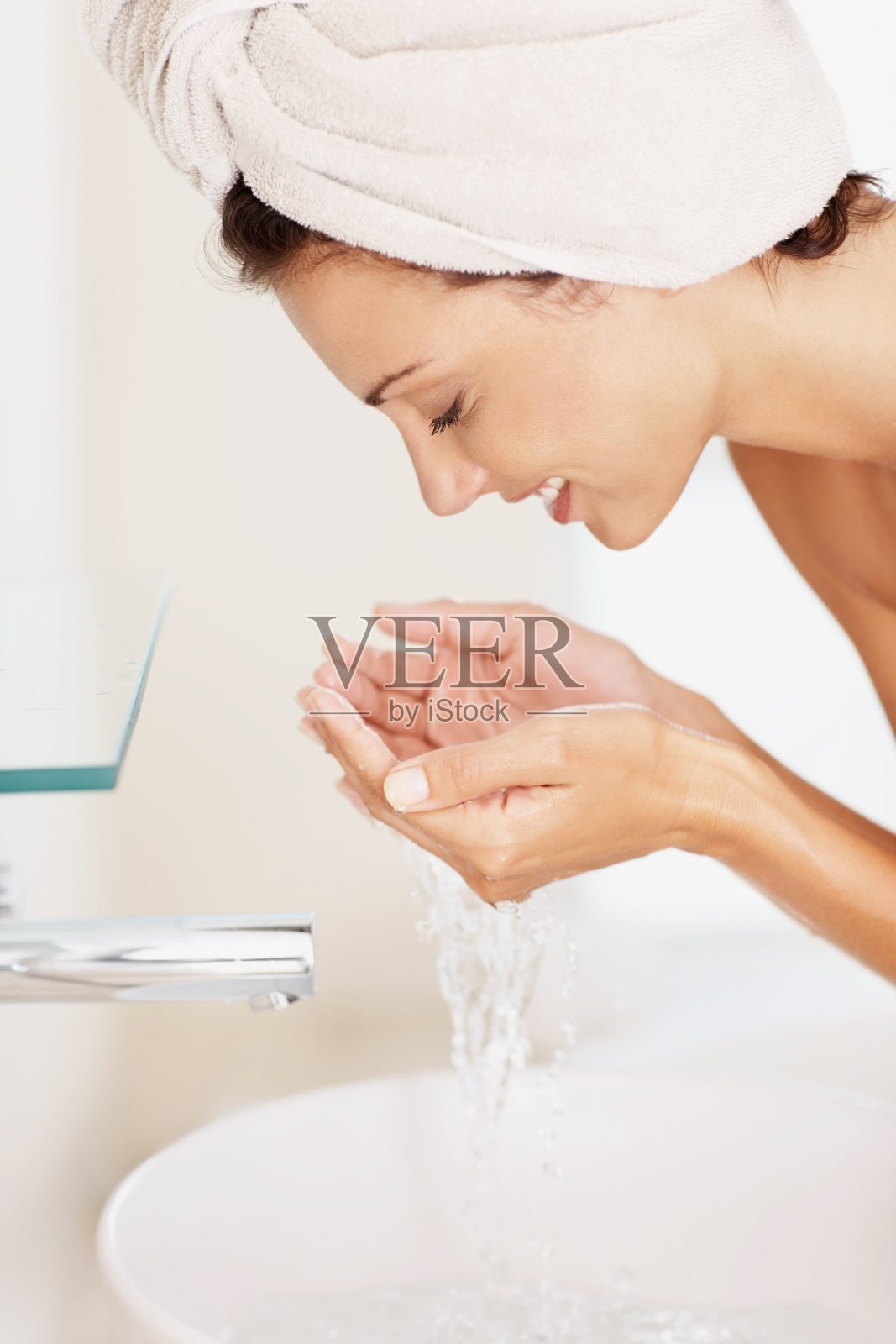 一个女人在用水洗脸照片摄影图片