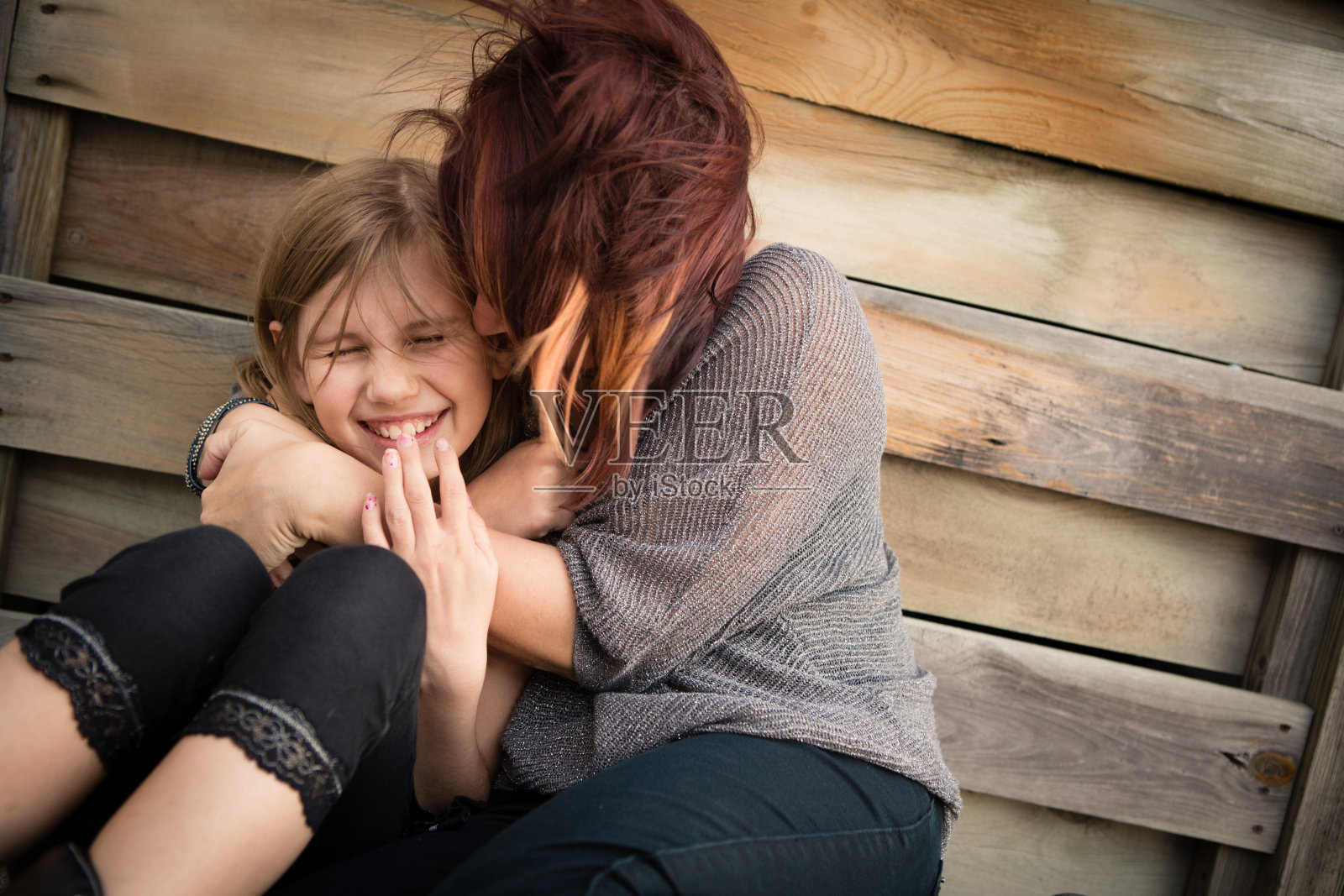 母亲和小女儿拥抱，在户外设置照片摄影图片