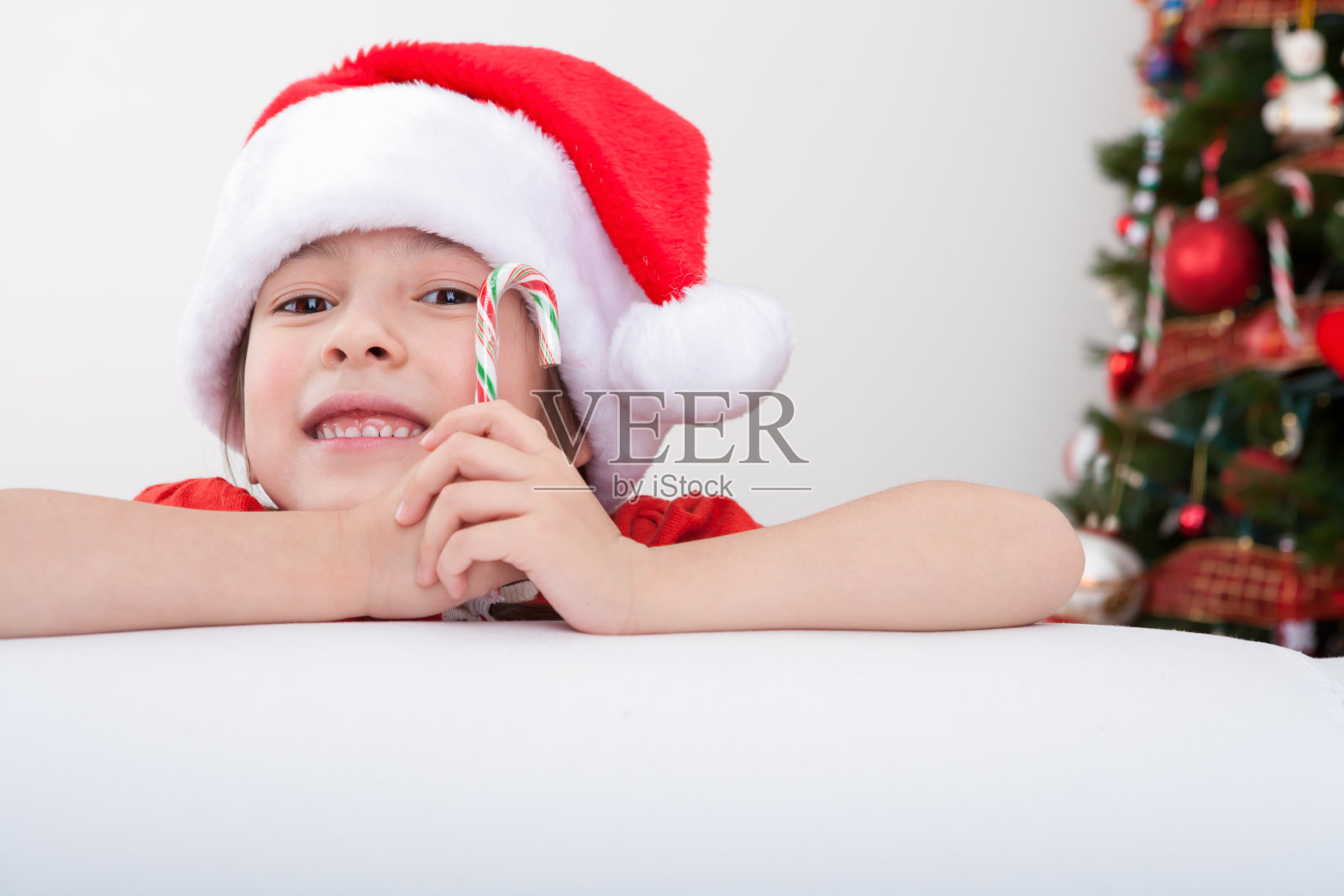 圣诞快乐的女孩戴着圣诞老人的帽子照片摄影图片