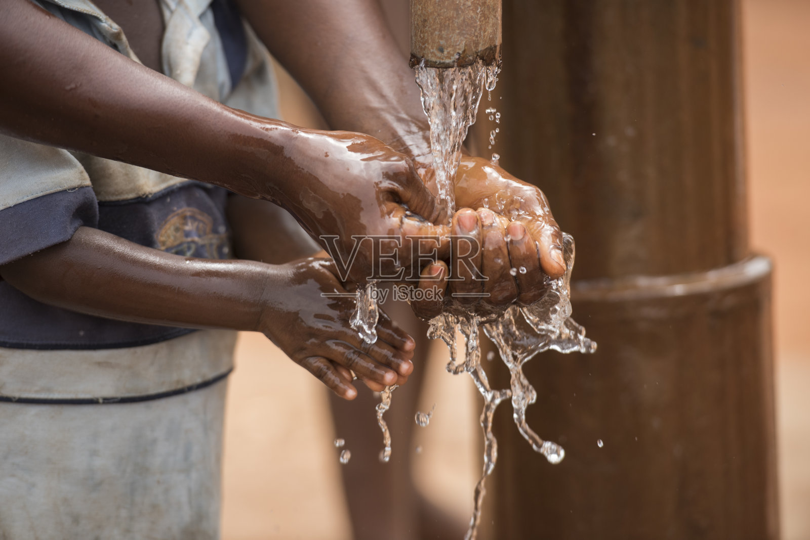 母亲和孩子用干净的水洗手照片摄影图片