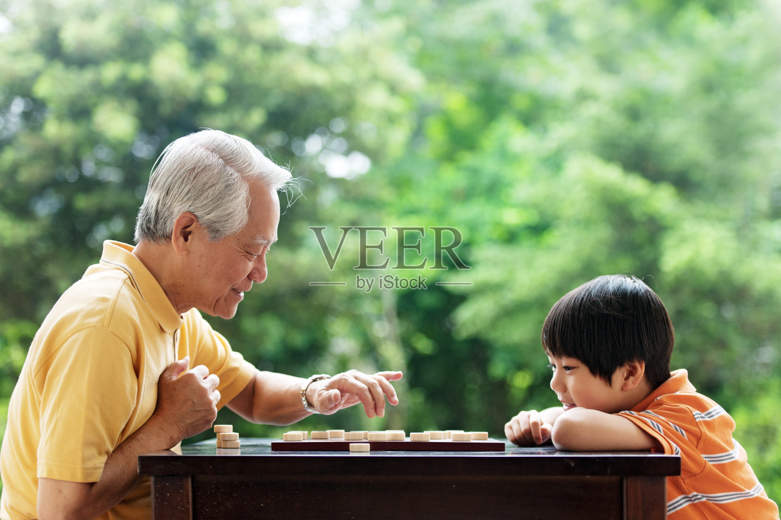 爷爷和孙子在玩象棋照片摄影图片