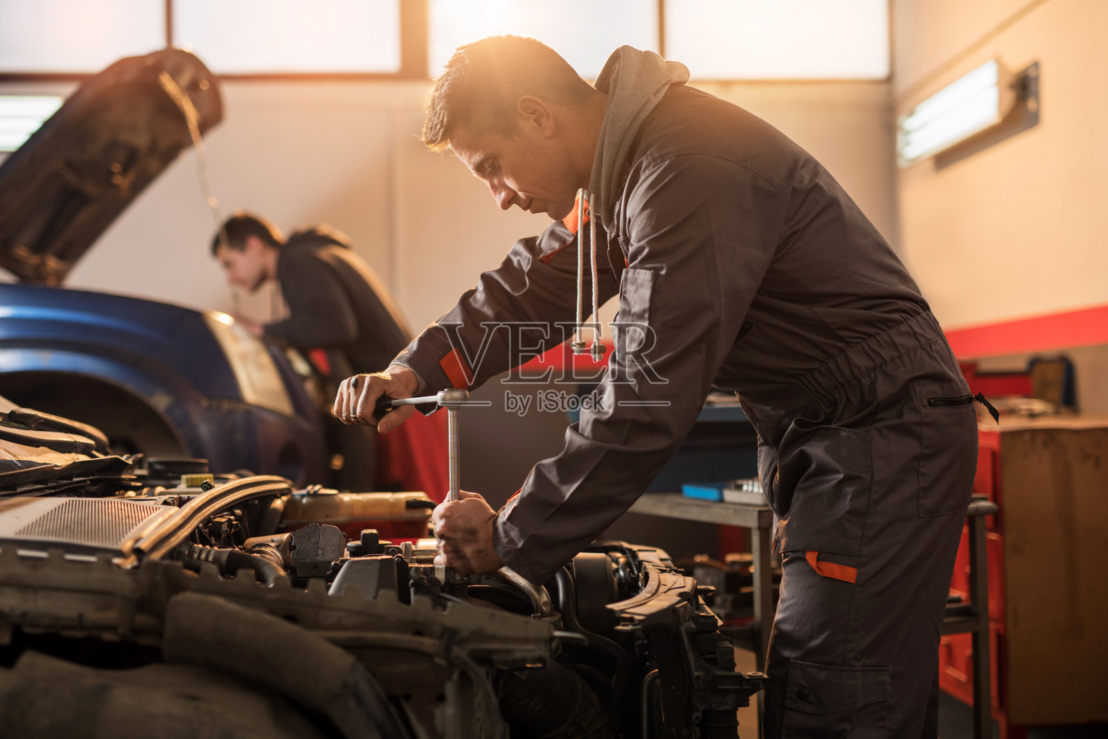 汽车修理工在修理厂修理汽车发动机。照片摄影图片