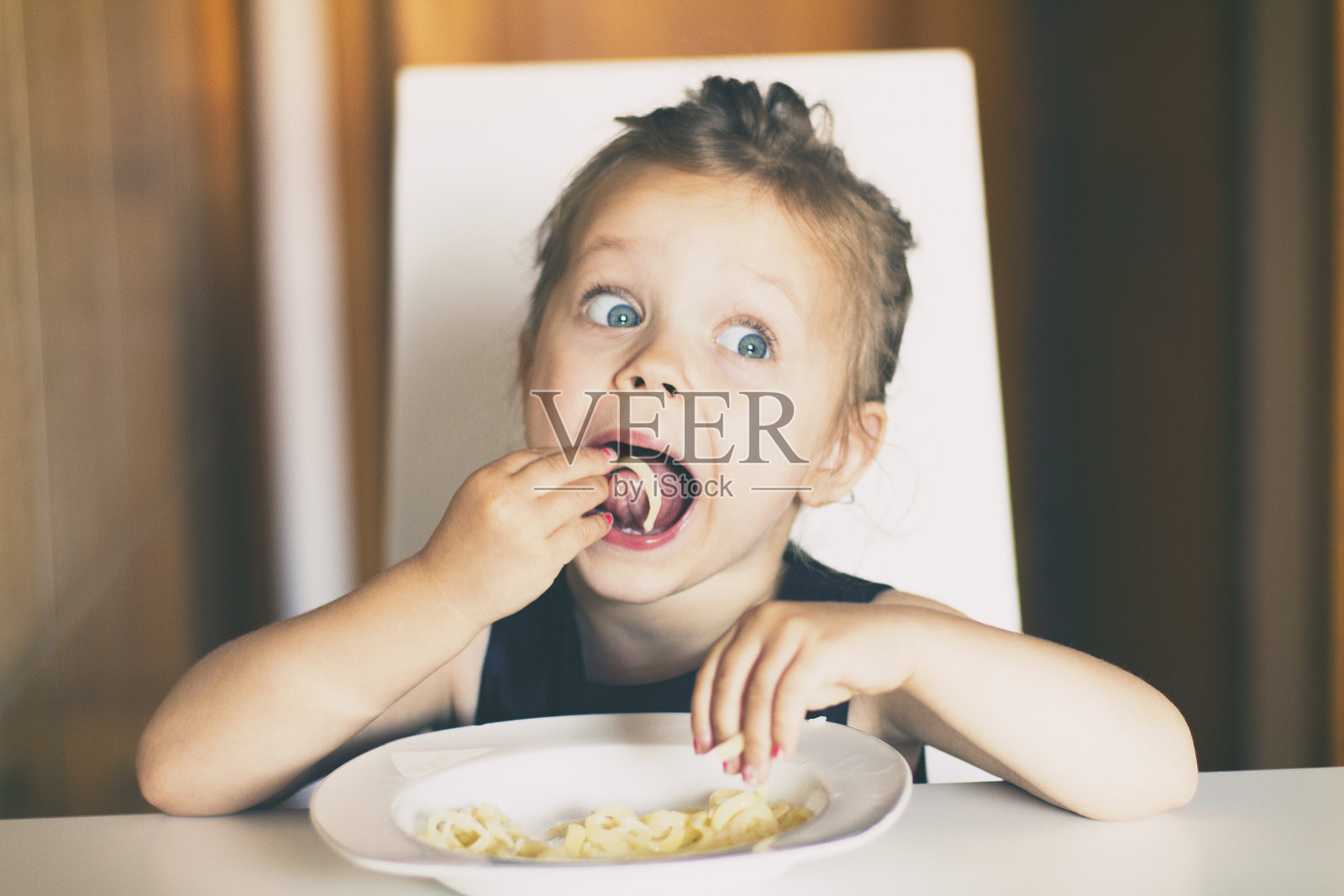 小女孩吃意大利面照片摄影图片
