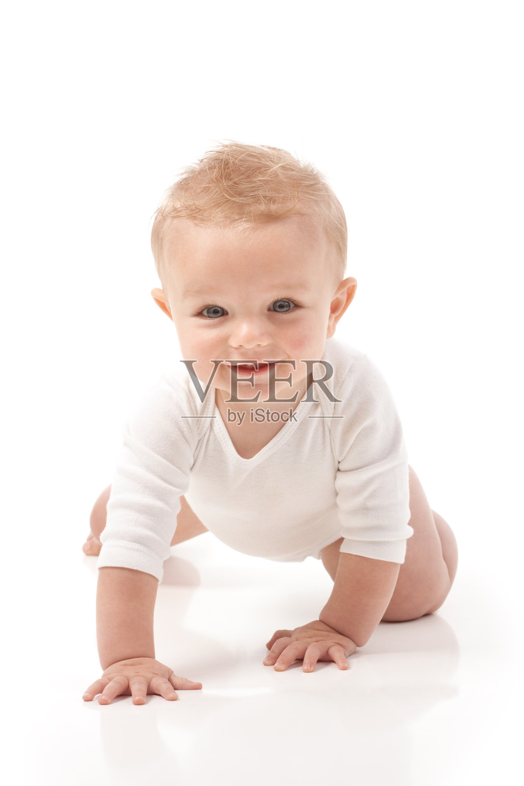 快乐的九个月大的婴儿爬在白色的背景照片摄影图片