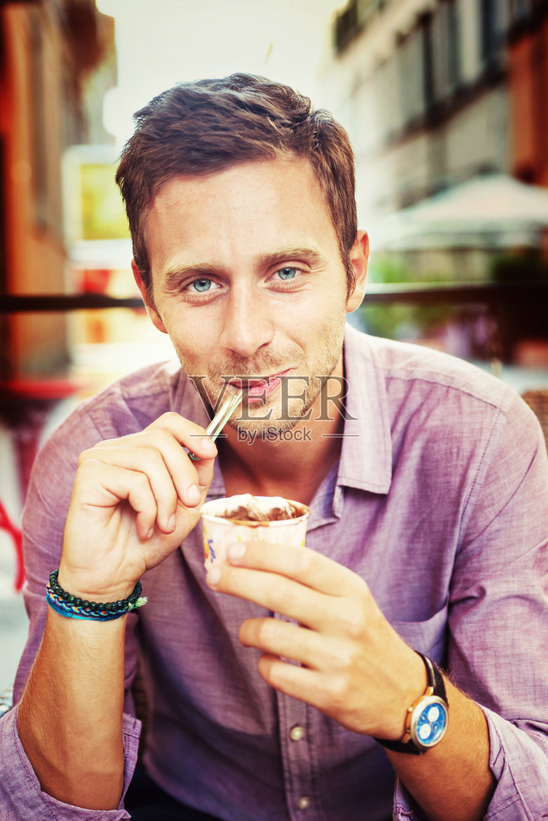 穿着紫色衬衫，吃着冰淇淋的男人照片摄影图片