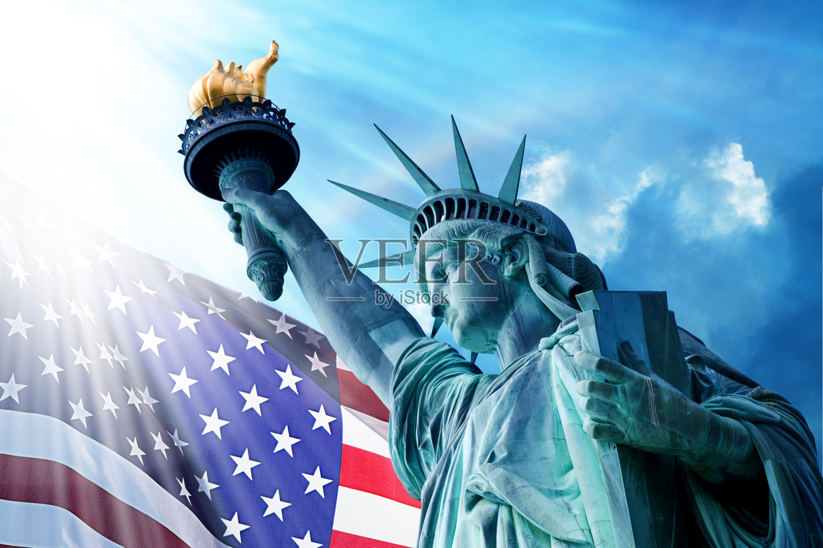 蓝天下的自由女神像和美国国旗照片摄影图片