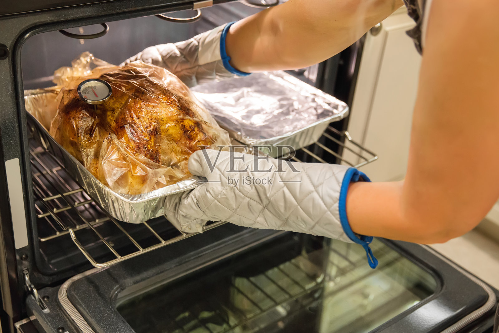 烤火鸡，温度计从烤箱里出来照片摄影图片