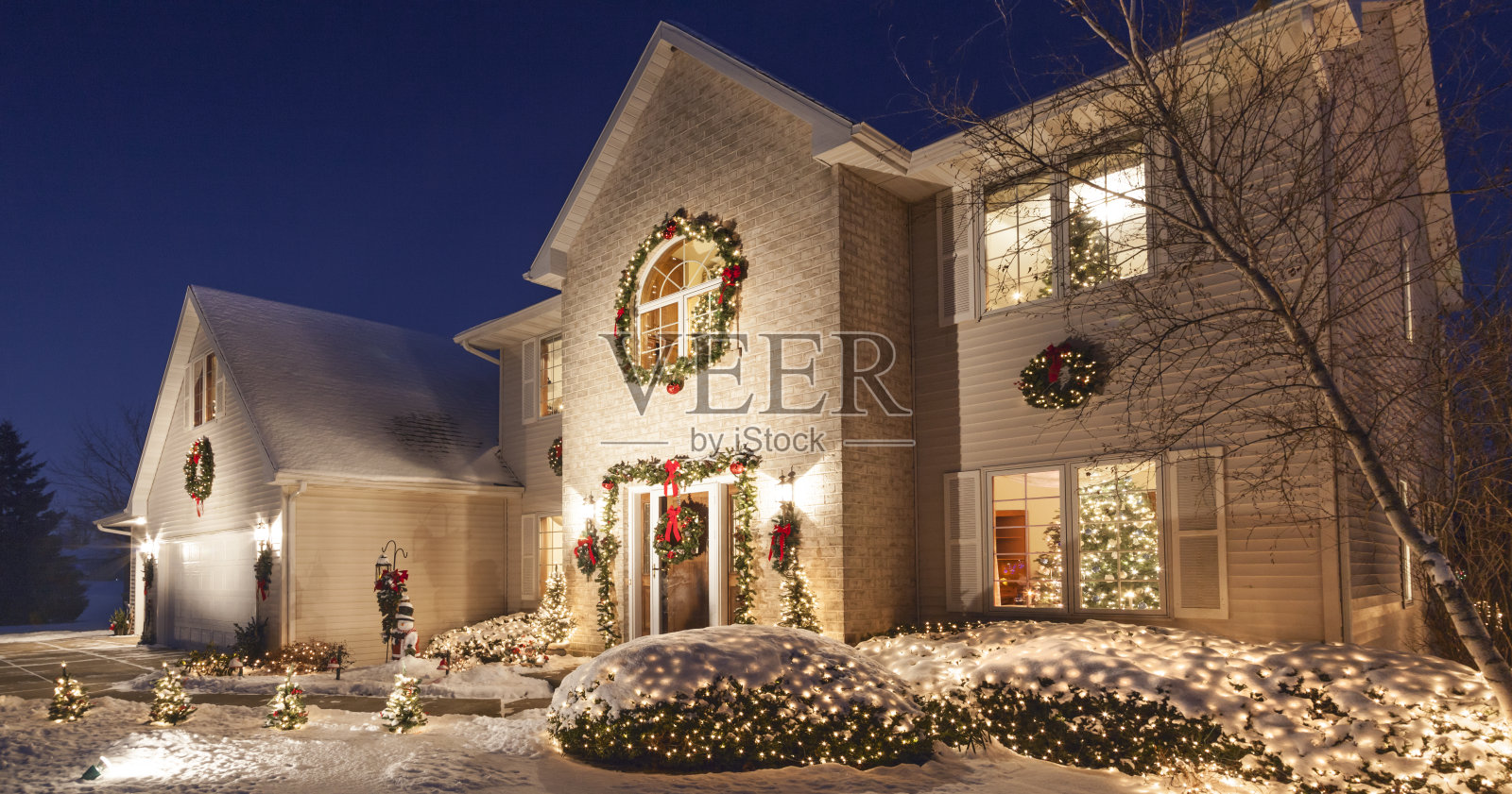 晚上用圣诞灯光和蓬松的雪花把家里装饰得完美无缺照片摄影图片