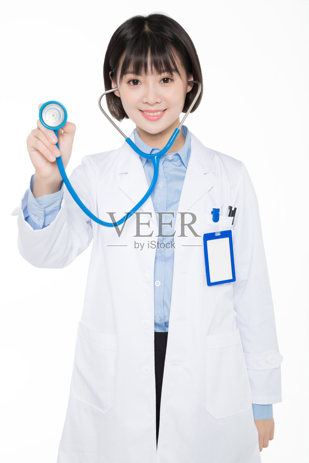 年轻的微笑女医生举着听诊器的肖像照片摄影图片