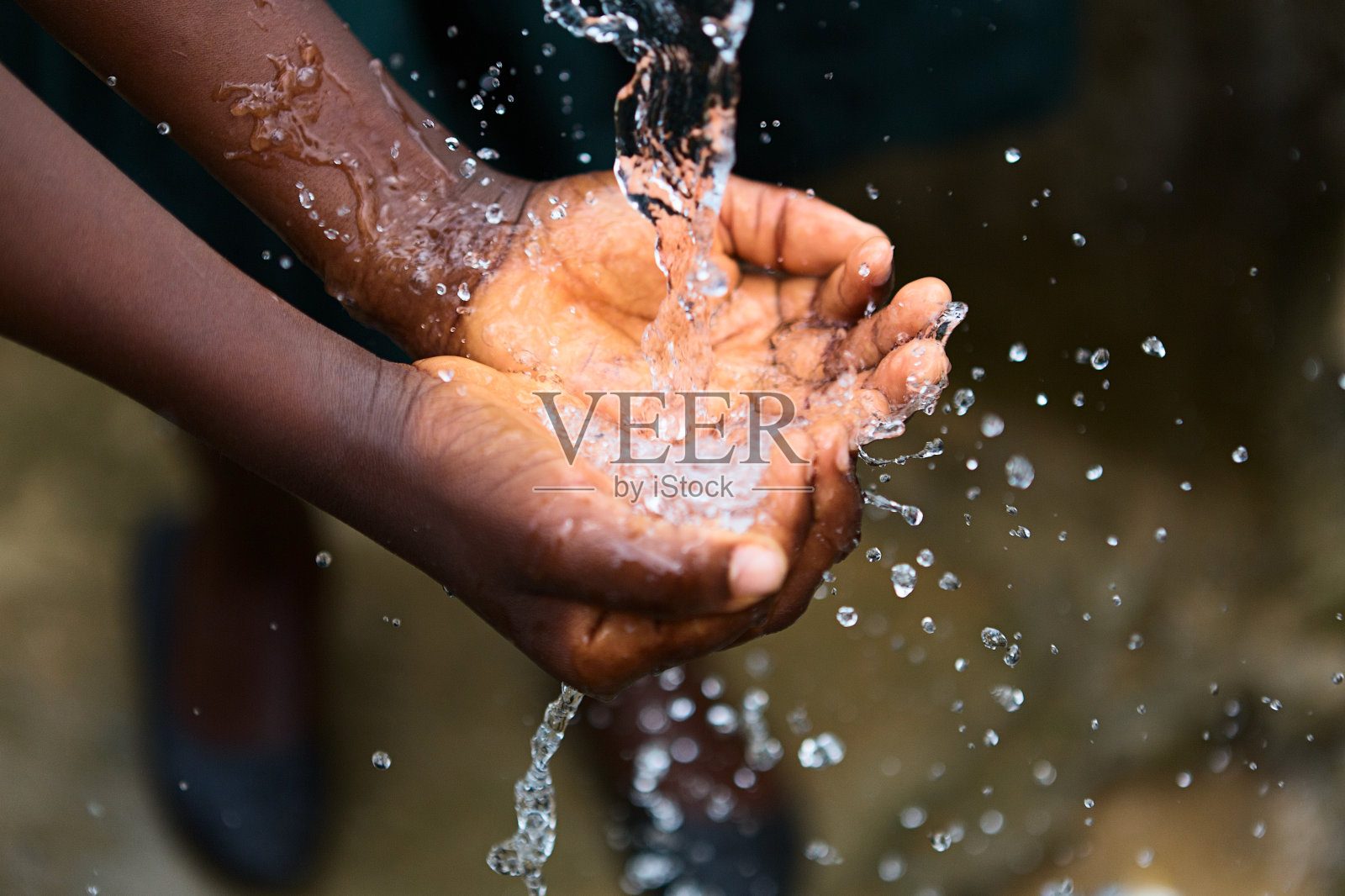 可怜的孩子双手舀着饮用水，非洲照片摄影图片