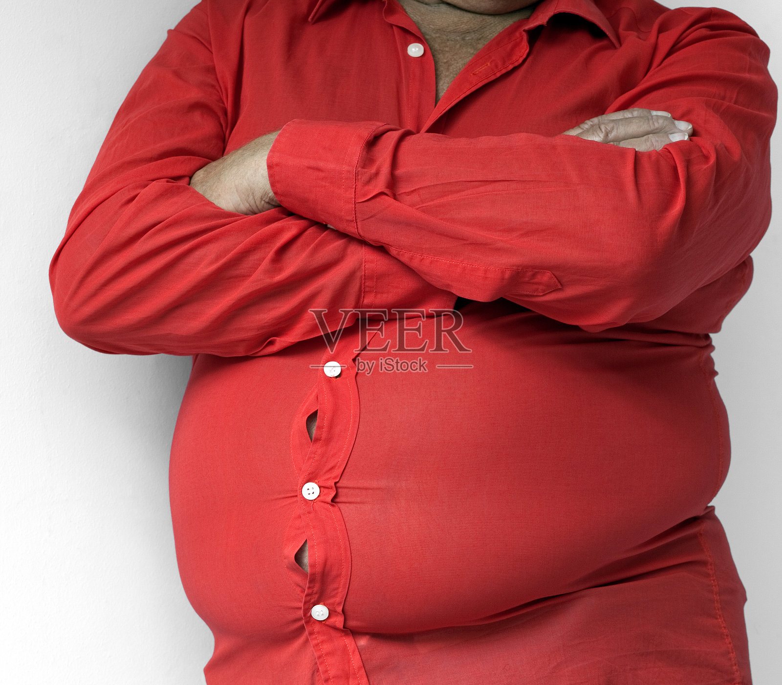 一个穿着红色衬衫的黑人，他的肚子在倾倒照片摄影图片