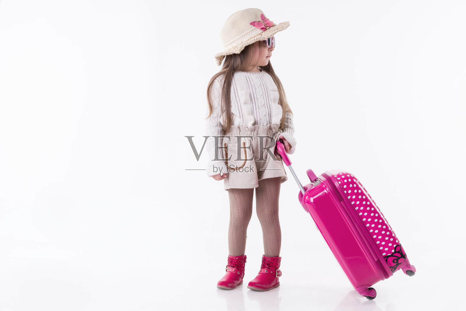 年轻的女孩穿着节日的衣服拉着手提箱照片摄影图片