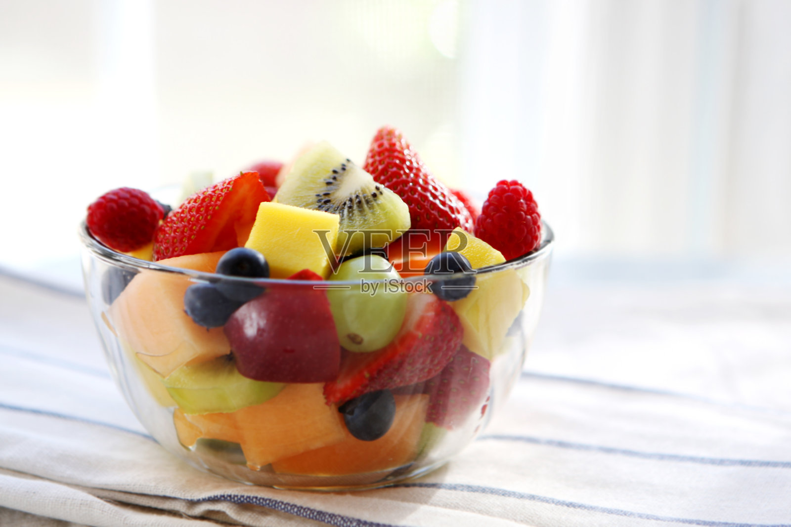 用抹布擦干净一碗切好的夏季水果照片摄影图片