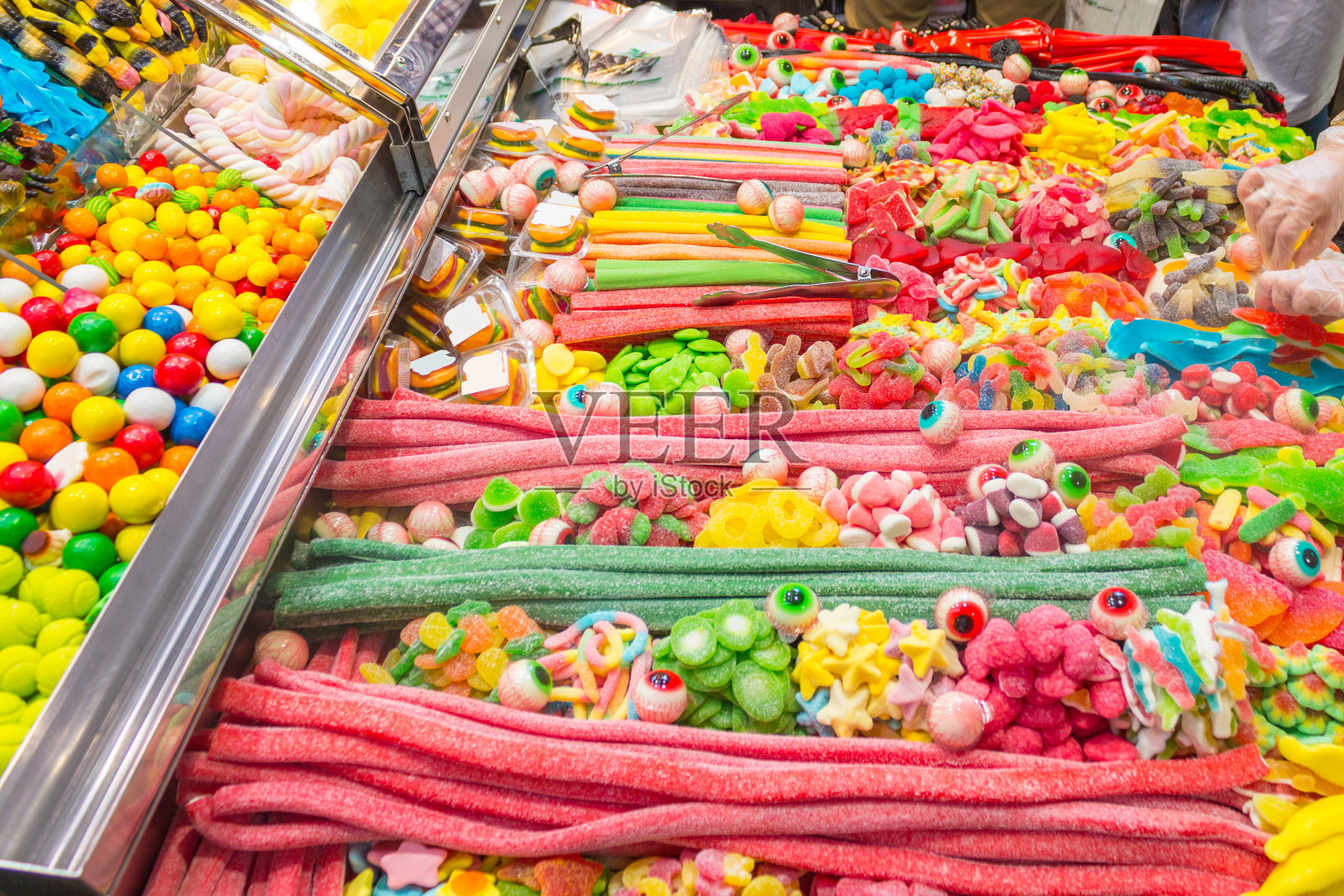 市场里有很多五颜六色的糖果。照片摄影图片