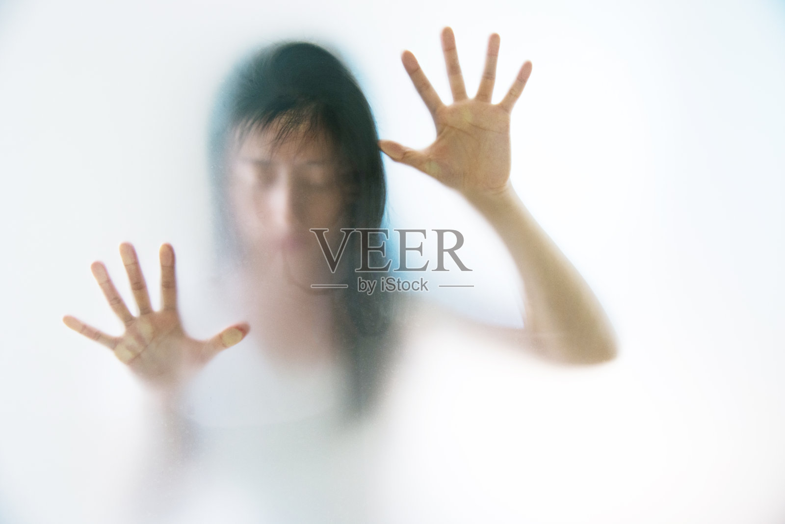女人的手在磨砂玻璃后面做着恐惧的手势照片摄影图片