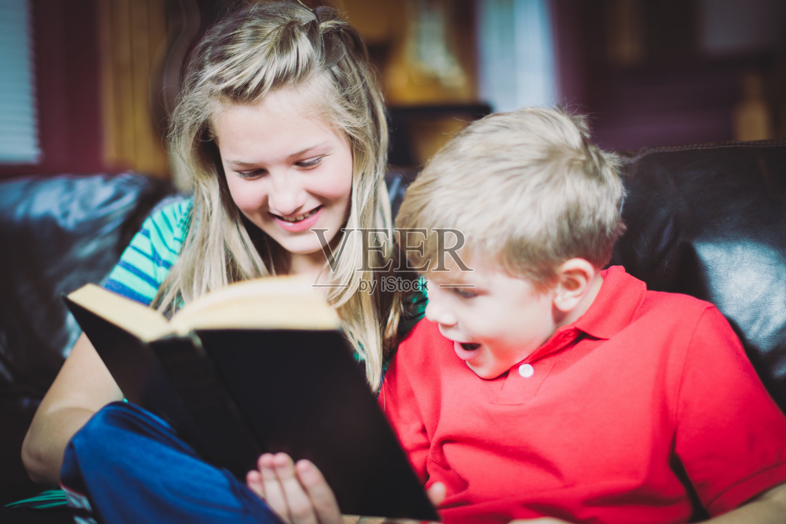 妹妹和弟弟在一起读一本书照片摄影图片