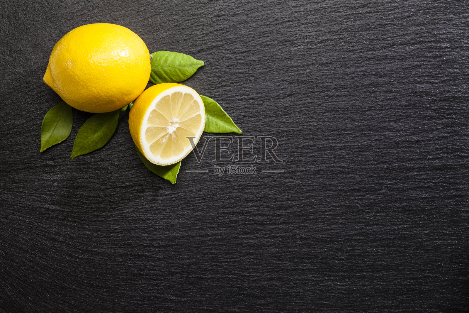 黑石板桌上放着柠檬照片摄影图片