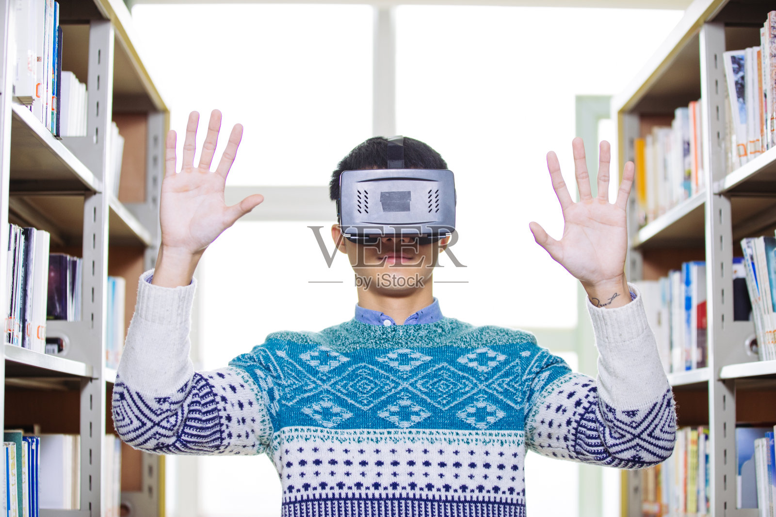 年轻的亚洲人戴着虚拟现实在图书馆照片摄影图片
