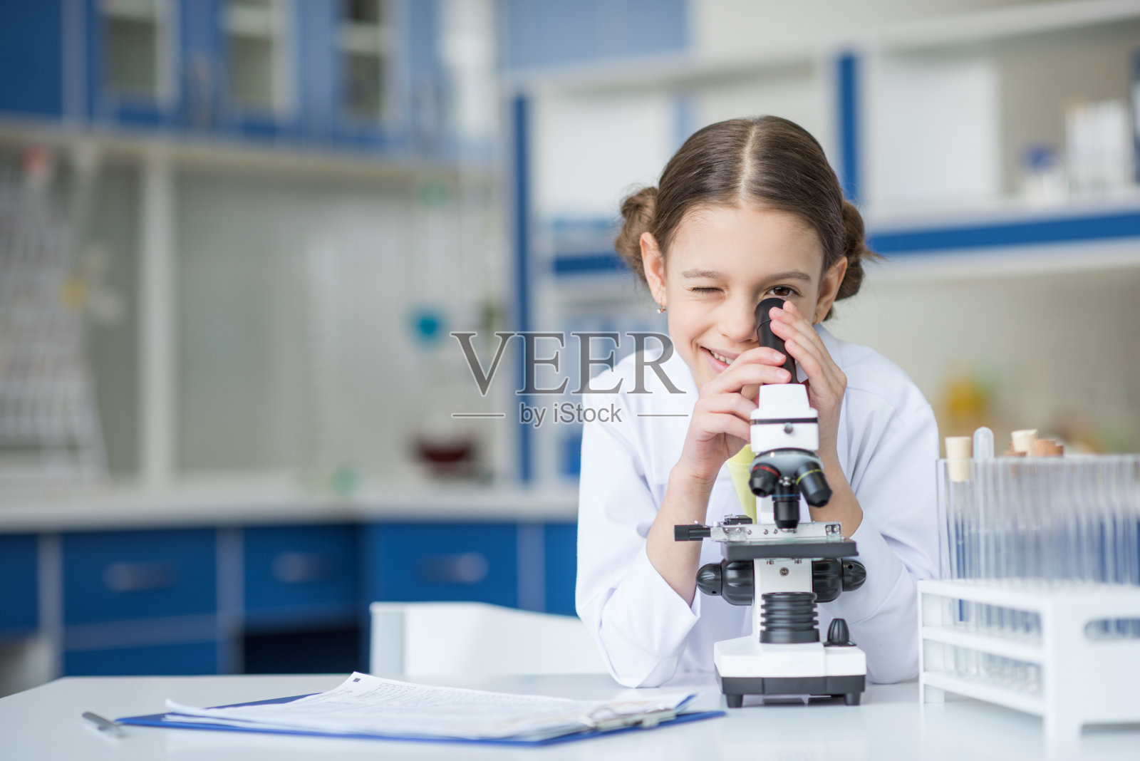 微笑的女科学家在实验室用显微镜工作照片摄影图片