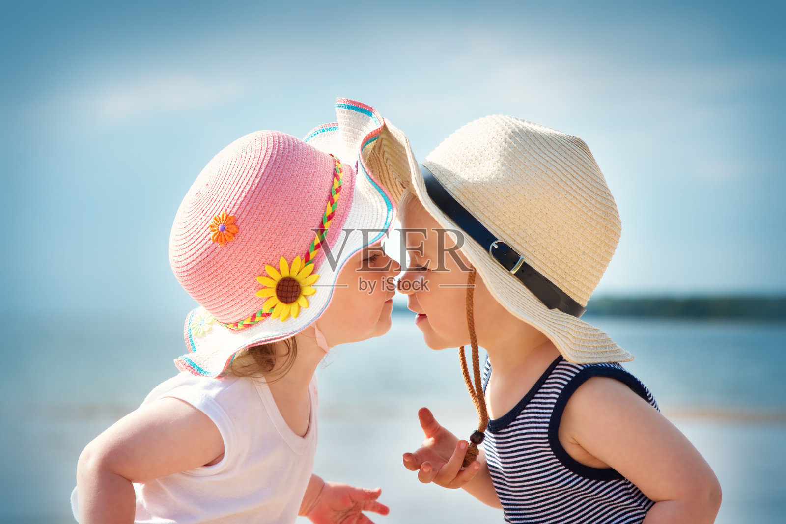 小女孩和小男孩在沙滩上接吻照片摄影图片