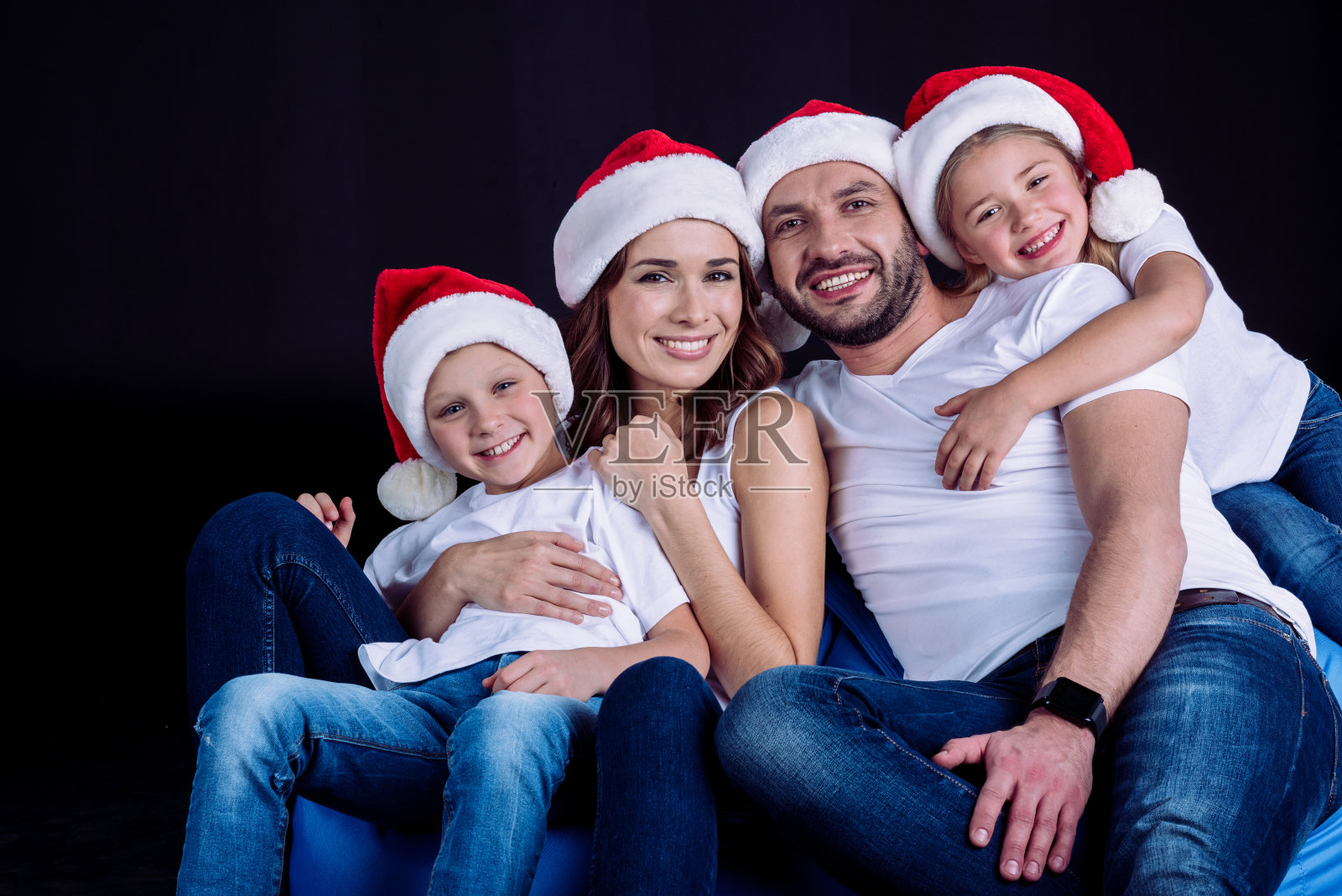 一家人戴着圣诞帽看着镜头照片摄影图片