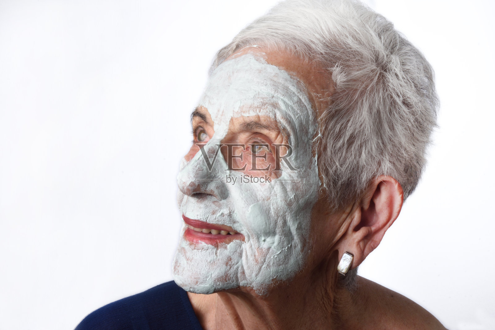 年长妇女与facian面具在白色照片摄影图片