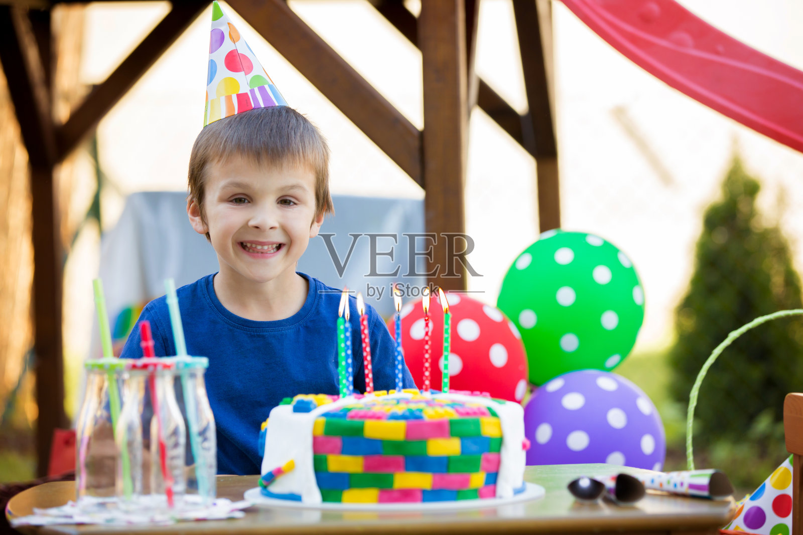 可爱的小男孩，庆祝他的六岁生日，蛋糕，气球，蜡烛，饼干。童年幸福的概念照片摄影图片