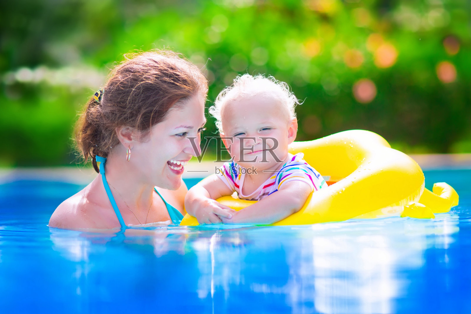 漂亮的妈妈和宝宝在游泳池里照片摄影图片
